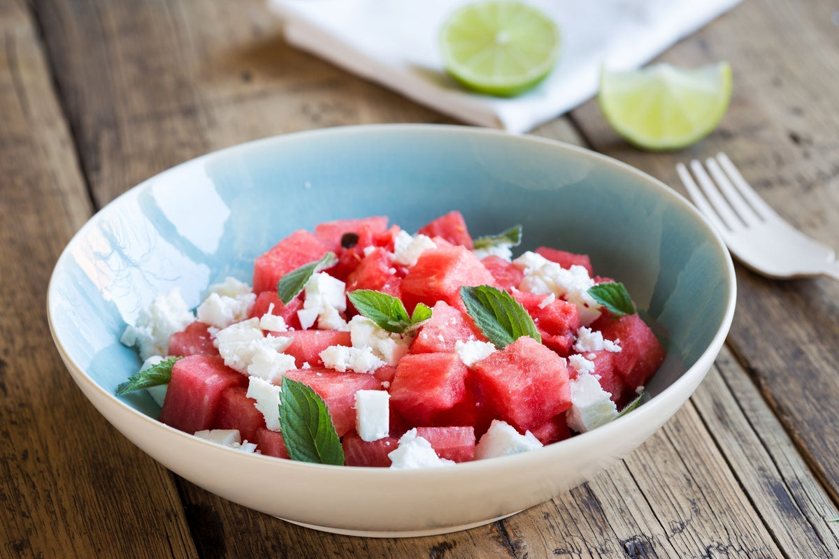 Wassermelonen-Feta-Salat mit Honig-Dressing auf Teller angerichtet